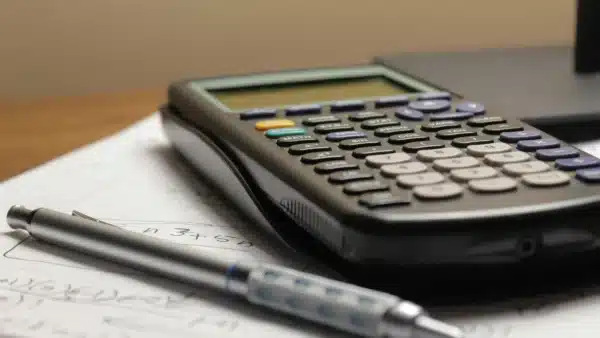 Kostenrechner und Kugelschreiber auf einem Schreibtisch